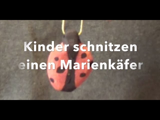 Kinder schnitzen einen Marienkäfer Anhänger